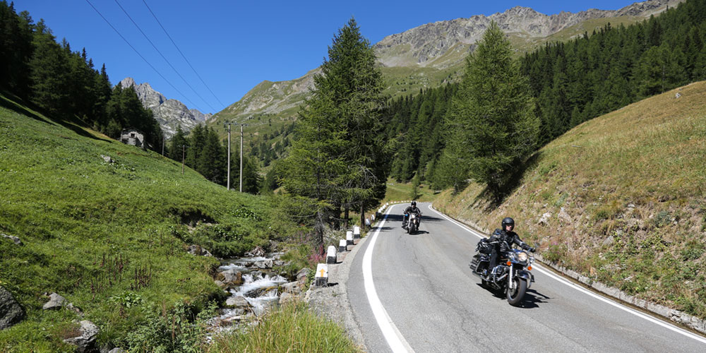 2 Motorradfahrern fahren über den großen Sankt Bernhard Pass in der Schweiz nach Italien