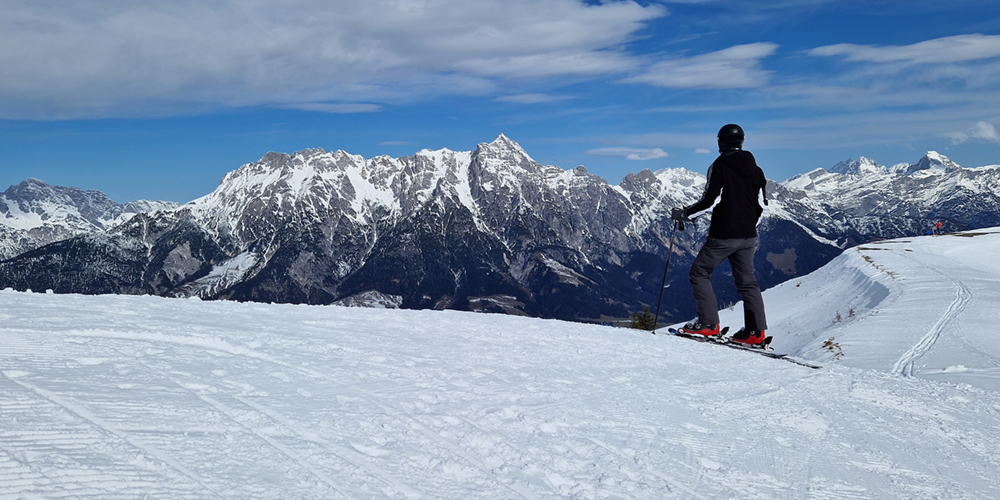 Skifahrerin schaut auf die Leoganger Steinberge 