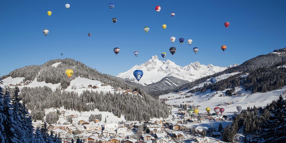 Viele bunte Heißluftballons im Himmel über Filzmoos