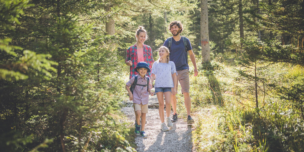 Eine Familie wandert auf dem Naturerlebnisweg Mitteregg rund um die Zugspitze in den Alpen