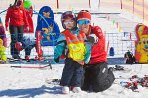 Kind mit Mama lernt Ski in den Alpen